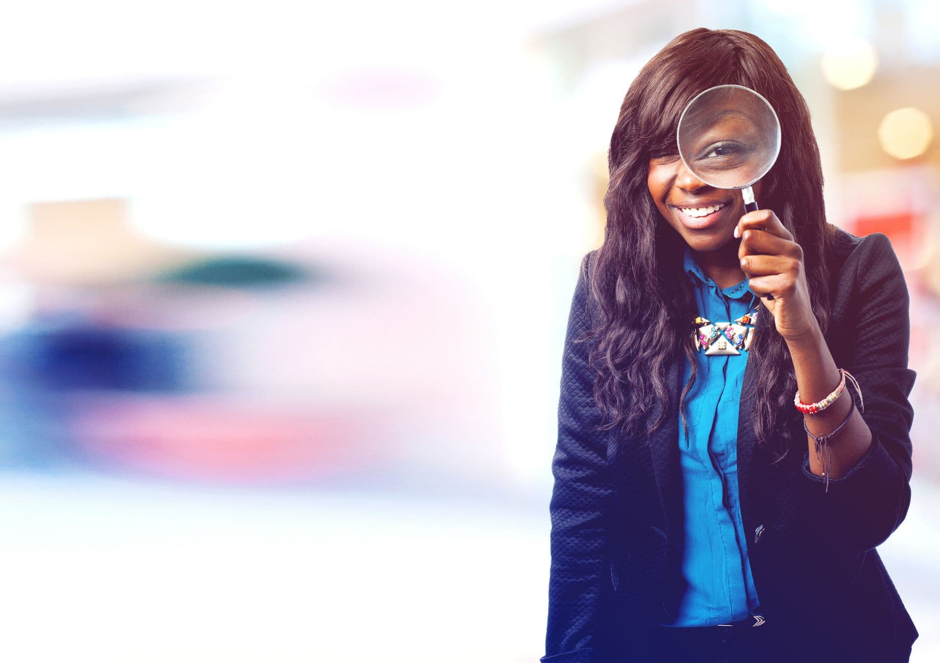 Smiling professional looking through a magnifying glass